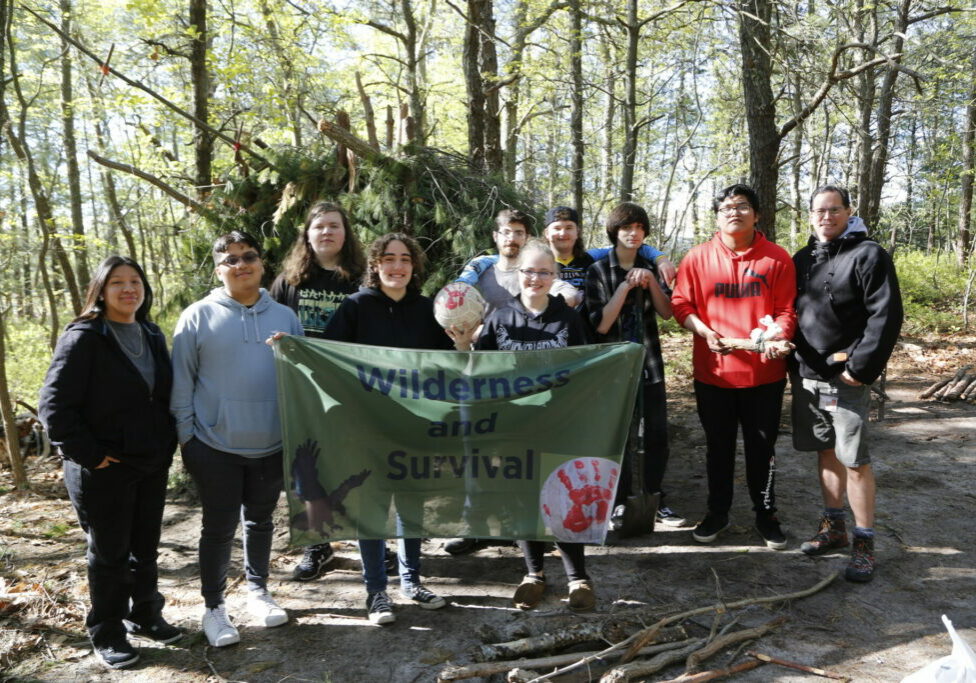 Mark Haug and several Wilderness Survival students display the class banner and “Wilson,” their mascot.