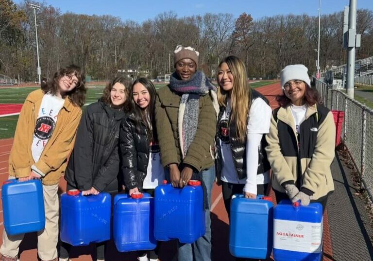 TEEEM Club students at Northern Highlands Regional High School during a 5K fundraising walk as they carry water containers in November 2022. With them is Georgie Badiel, author of The Water Princess. 