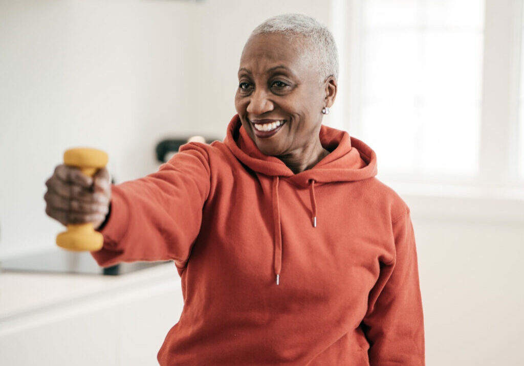 senior Black woman holding a weight